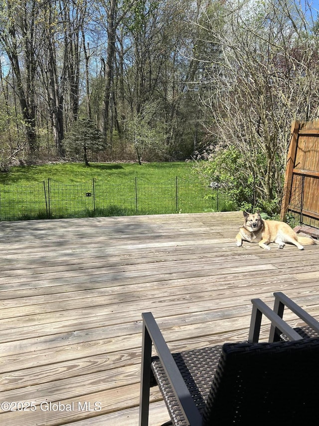 wooden deck featuring a lawn and fence