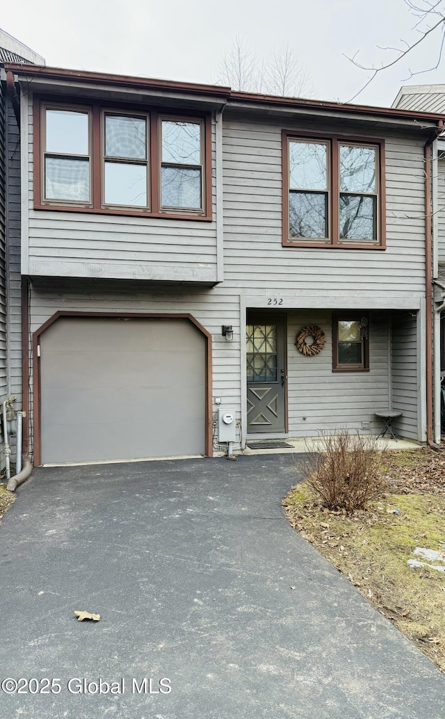 townhome / multi-family property with an attached garage and driveway