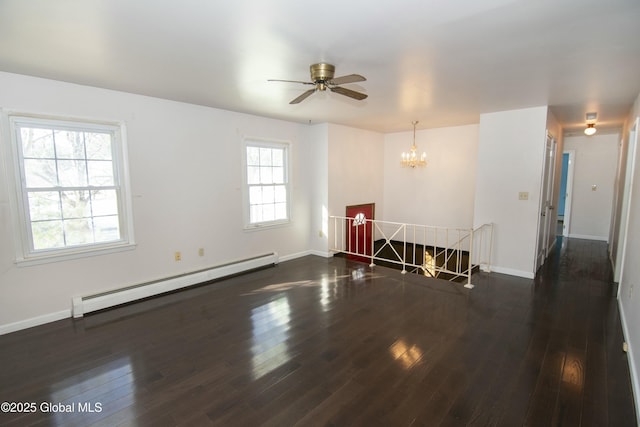 spare room featuring a baseboard heating unit, dark wood-type flooring, and a chandelier