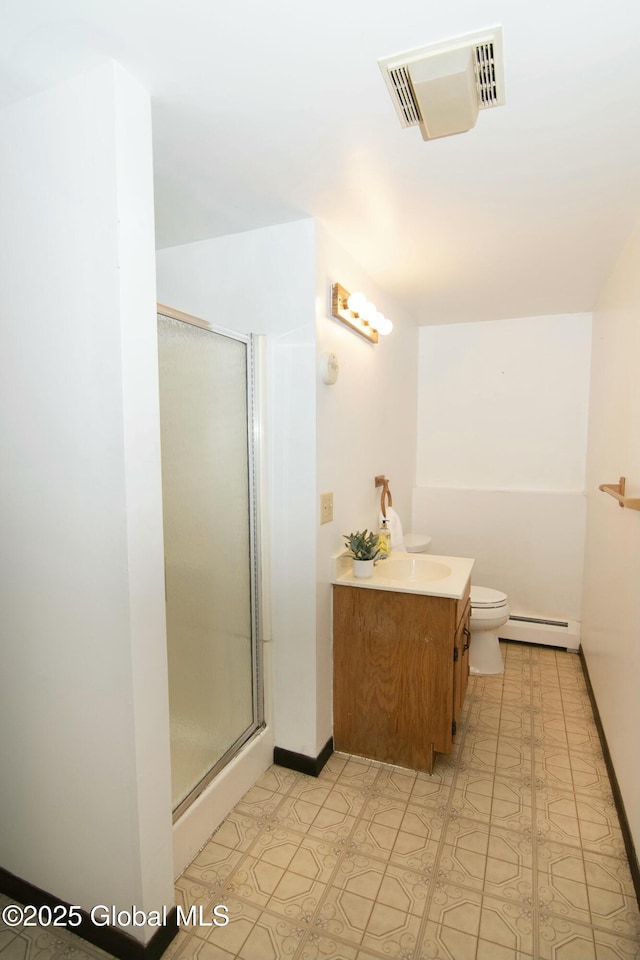 bathroom with vanity, toilet, a shower with door, and a baseboard heating unit