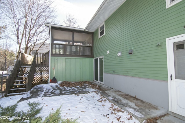 view of snow covered exterior featuring a sunroom