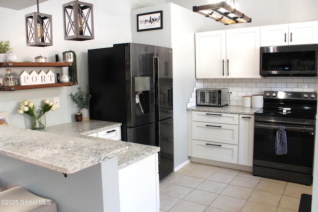 kitchen featuring decorative light fixtures, black appliances, white cabinets, light tile patterned floors, and kitchen peninsula