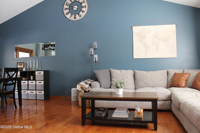 living room featuring wood-type flooring and vaulted ceiling