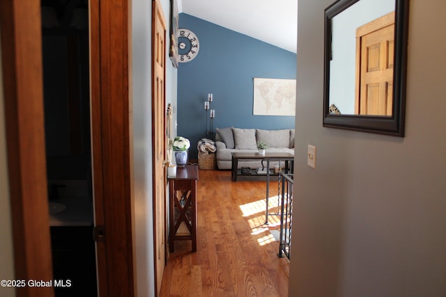 hall featuring vaulted ceiling and hardwood / wood-style floors