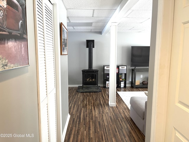 hallway featuring dark wood-type flooring and a paneled ceiling