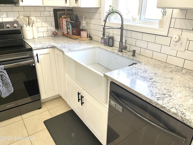 kitchen with light tile patterned floors, dishwasher, backsplash, light stone counters, and range with electric stovetop