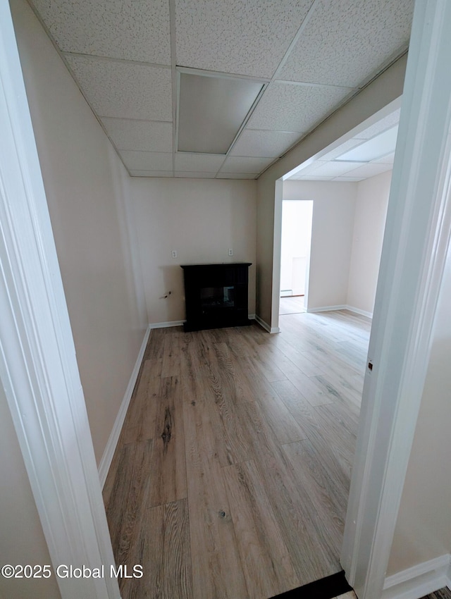 interior space featuring a paneled ceiling and hardwood / wood-style floors