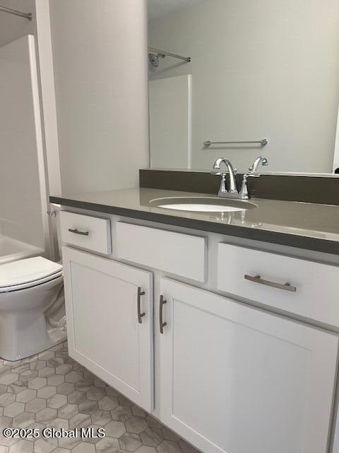 bathroom with toilet, vanity, and tile patterned flooring