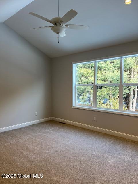 carpeted empty room with vaulted ceiling and ceiling fan