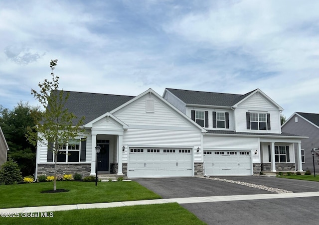 craftsman house with a front lawn and a garage