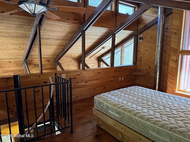 unfurnished bedroom with wooden ceiling, wood finished floors, beam ceiling, and wooden walls