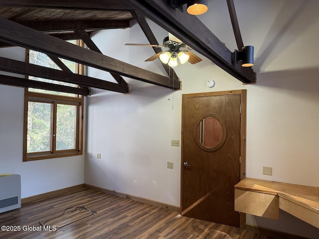 empty room featuring heating unit, wood finished floors, beam ceiling, and baseboards