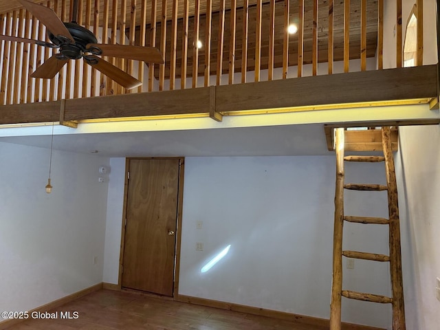 interior space featuring ceiling fan, wood finished floors, and baseboards