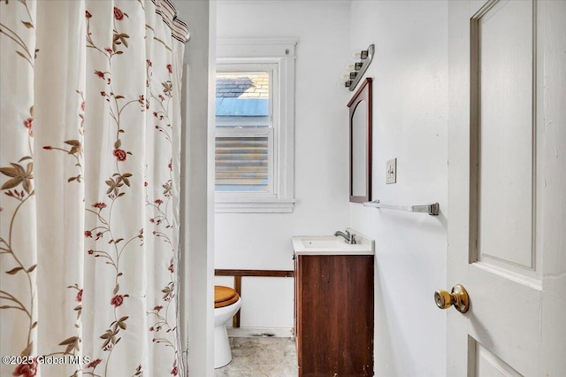 bathroom featuring vanity, walk in shower, and toilet