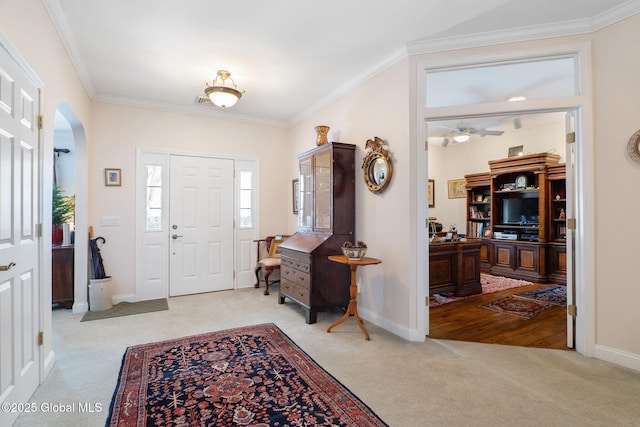 carpeted entrance foyer featuring ornamental molding