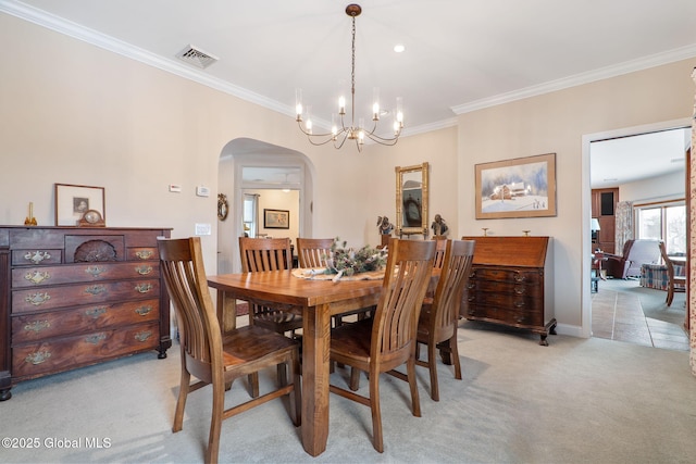 carpeted dining area with ornamental molding and a chandelier