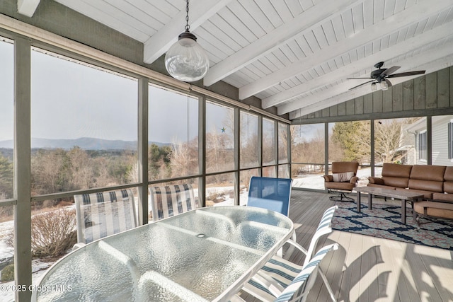 sunroom with plenty of natural light, vaulted ceiling with beams, and ceiling fan