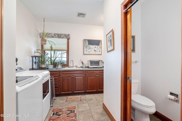 interior space with sink, washer and clothes dryer, and light tile patterned flooring