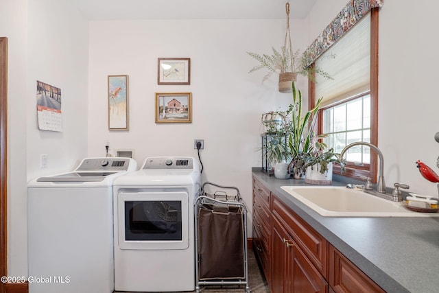 clothes washing area with cabinets, separate washer and dryer, and sink