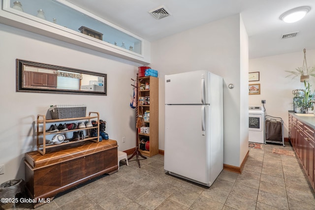 kitchen featuring washer / dryer and white fridge