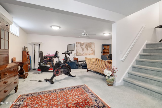 exercise room with ceiling fan, light colored carpet, and a wall mounted AC