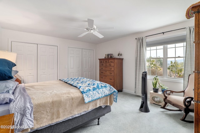 bedroom with carpet, two closets, and ceiling fan