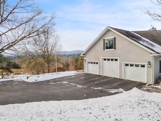 view of snow covered exterior with a garage