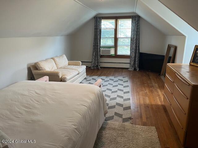 bedroom with a baseboard heating unit, dark wood-type flooring, and lofted ceiling