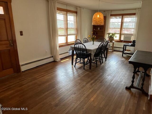 dining area featuring baseboard heating and dark hardwood / wood-style floors