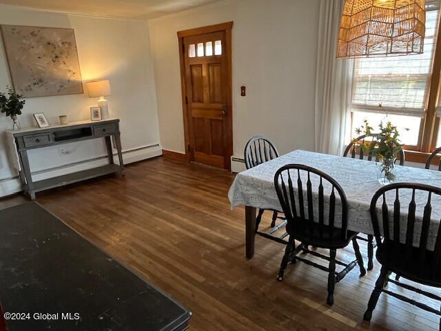 dining room with a baseboard radiator and dark hardwood / wood-style flooring