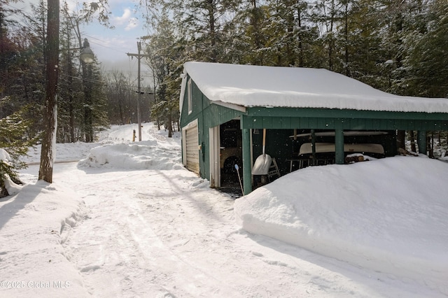 snow covered structure featuring a carport