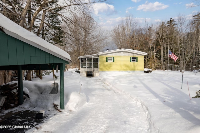 yard covered in snow with a sunroom