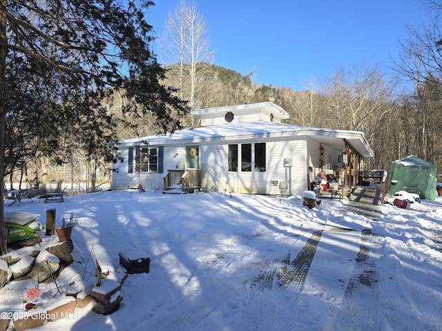 view of snow covered back of property