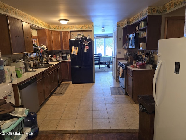 kitchen featuring stainless steel appliances, sink, and light tile patterned floors