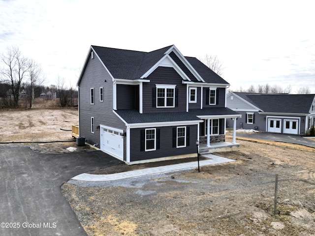 view of front of home with aphalt driveway, cooling unit, and a garage