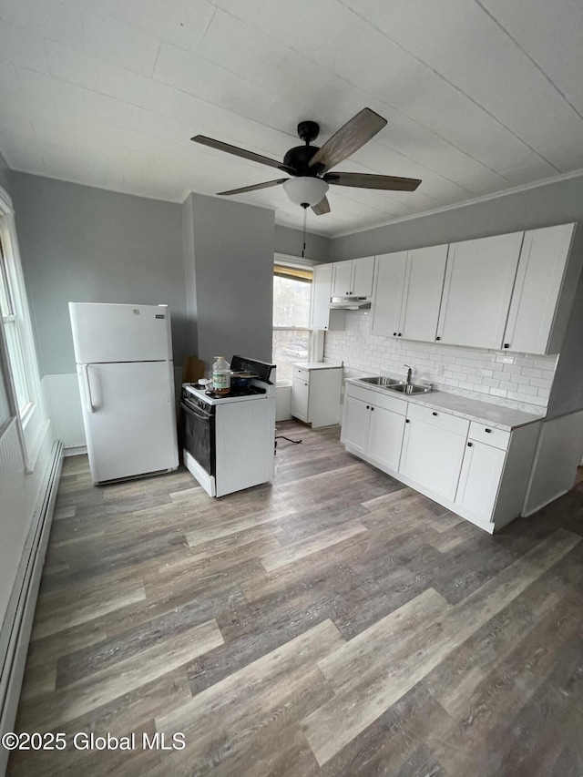 kitchen with backsplash, white fridge, white cabinetry, hardwood / wood-style flooring, and baseboard heating