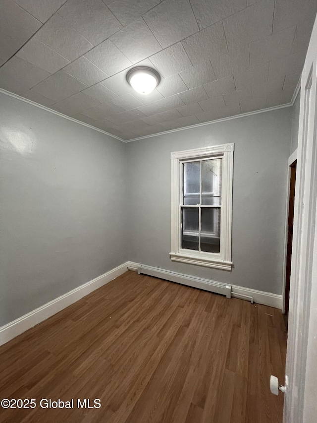 empty room featuring crown molding and hardwood / wood-style floors