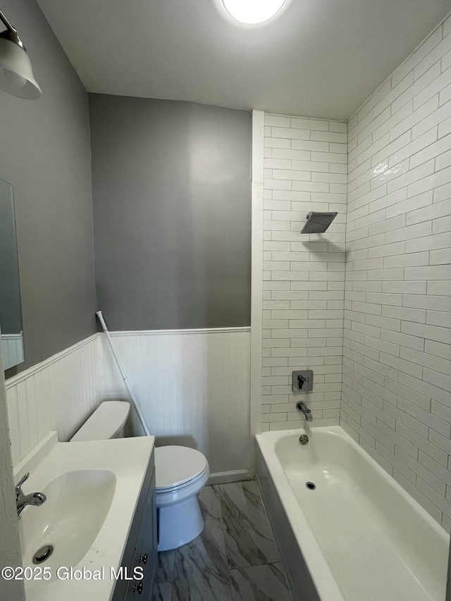 full bathroom featuring toilet, tiled shower / bath, and vanity