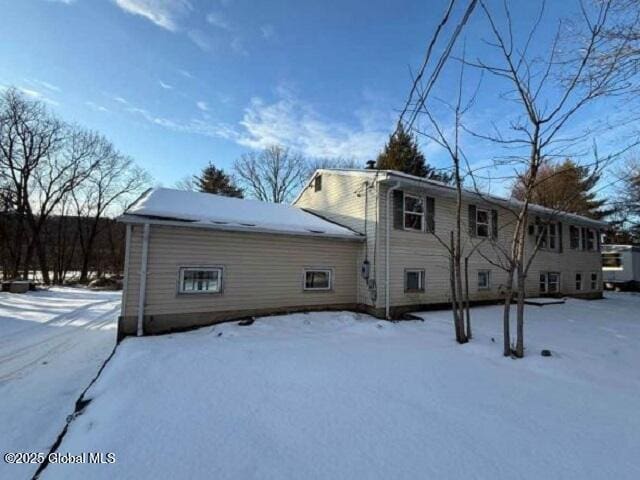 view of snow covered rear of property