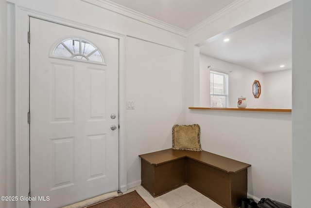 foyer featuring light tile patterned floors and crown molding