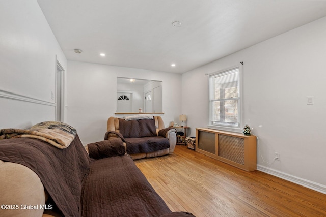 living room featuring radiator heating unit and light wood-type flooring