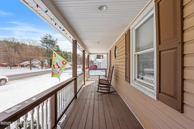 snow covered deck with covered porch