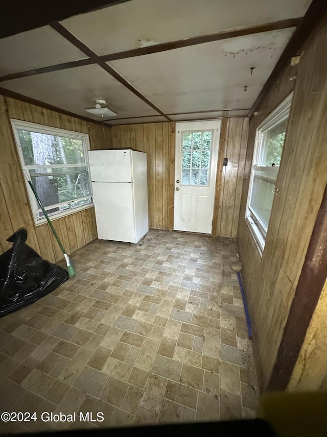 interior space with wooden walls and white fridge