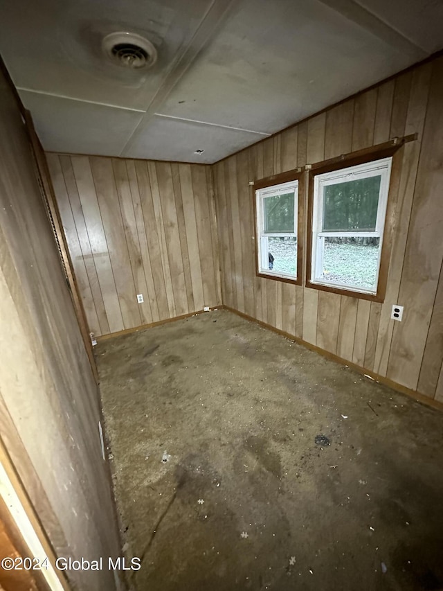 spare room featuring wood walls