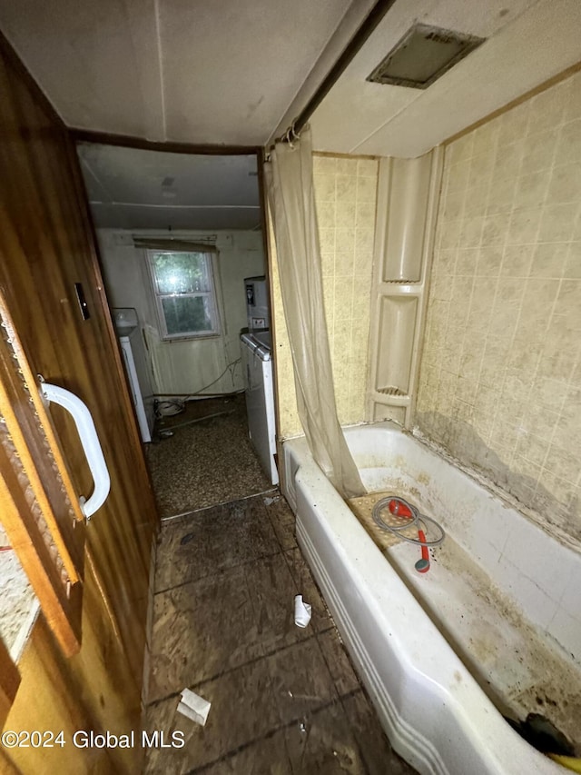 bathroom with shower / bath combo and washer / clothes dryer