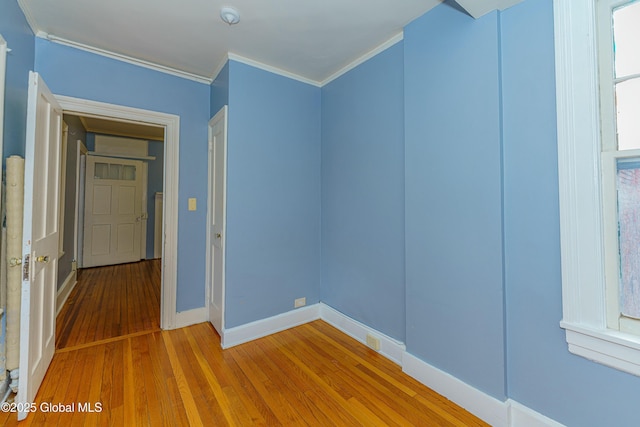 empty room with wood-type flooring and ornamental molding