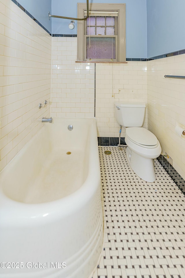 bathroom with toilet and tile walls