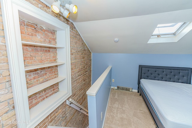 bedroom with light colored carpet, vaulted ceiling with skylight, and brick wall