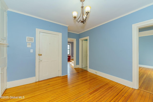 interior space with ornamental molding, a chandelier, and light hardwood / wood-style floors