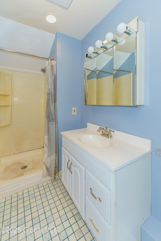 bathroom featuring walk in shower, tile patterned floors, and vanity